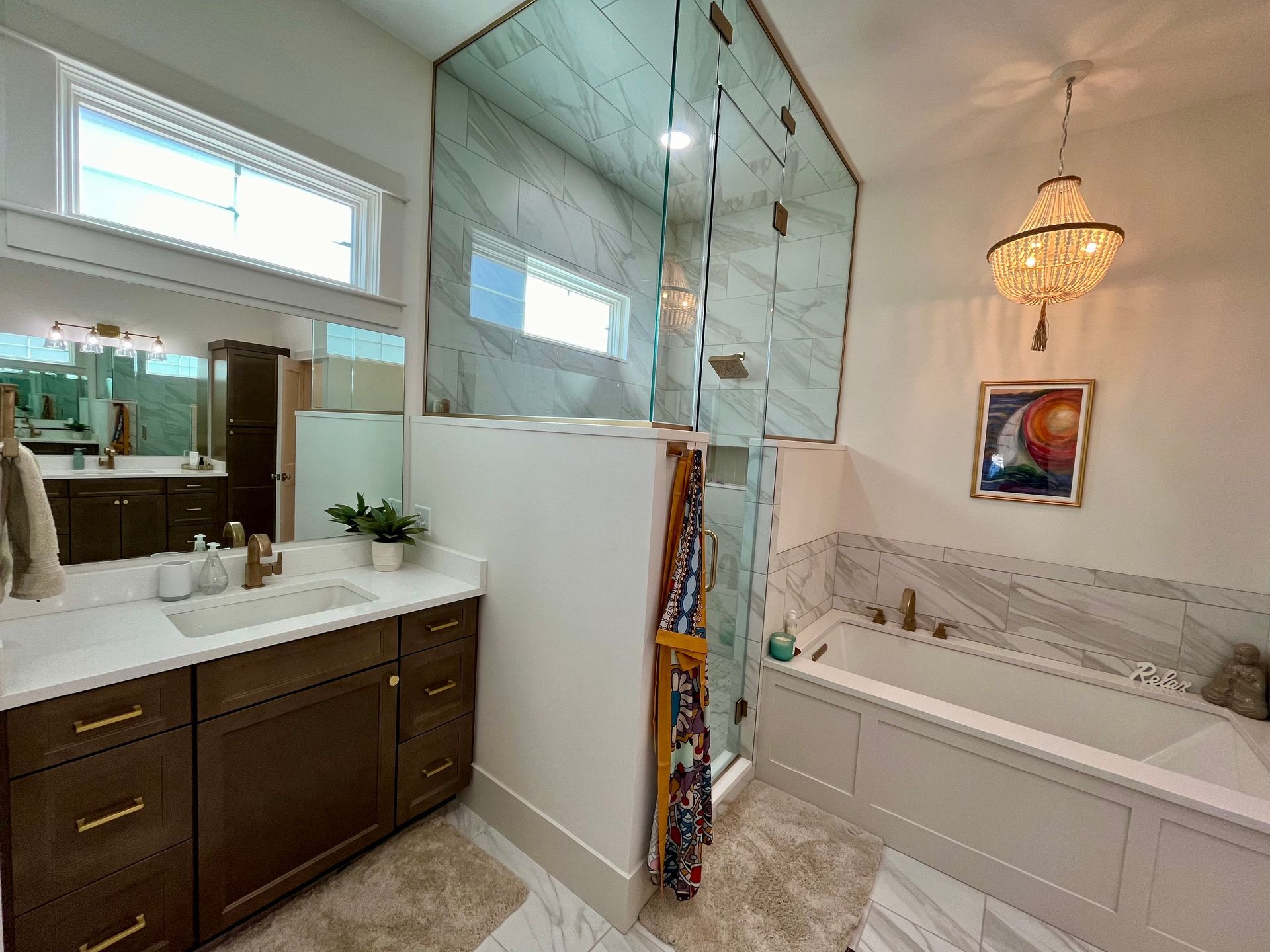 A bathroom with a tub , sink , mirror and walk in shower.