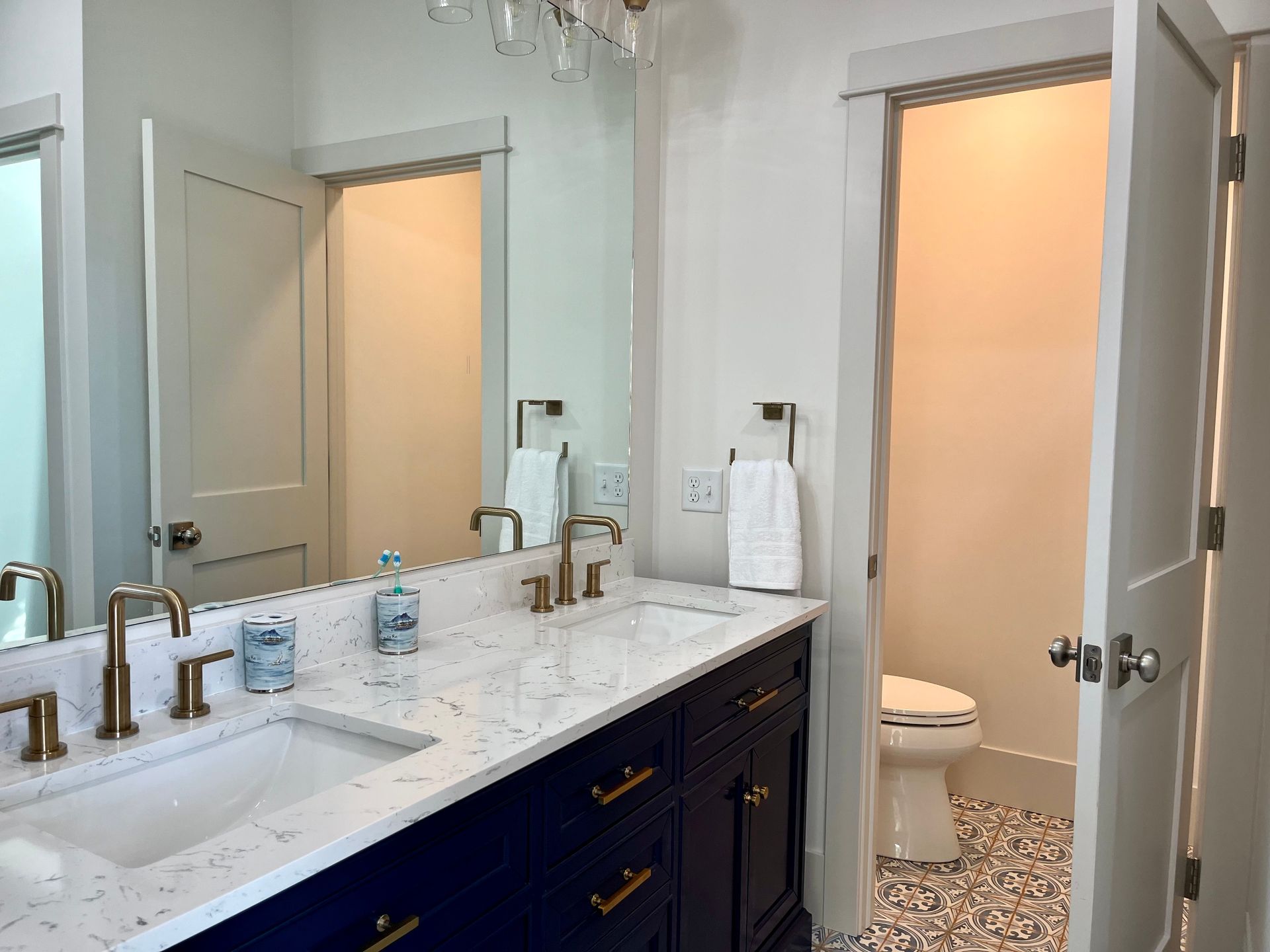 A bathroom with two sinks , a toilet and a mirror.