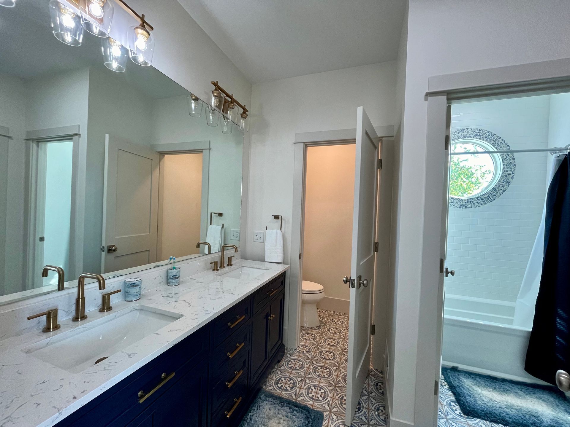 A bathroom with two sinks , a toilet , and a large mirror.