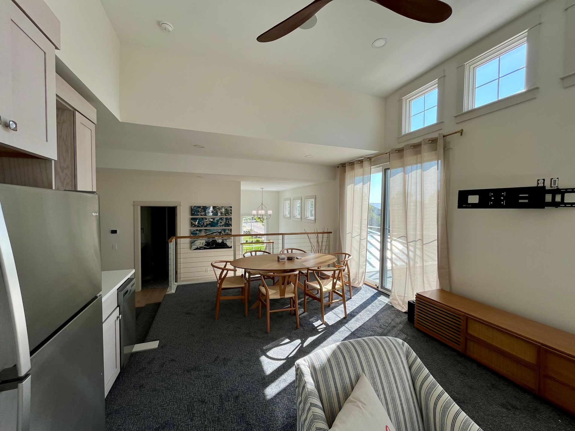 A living room with a table and chairs and a ceiling fan