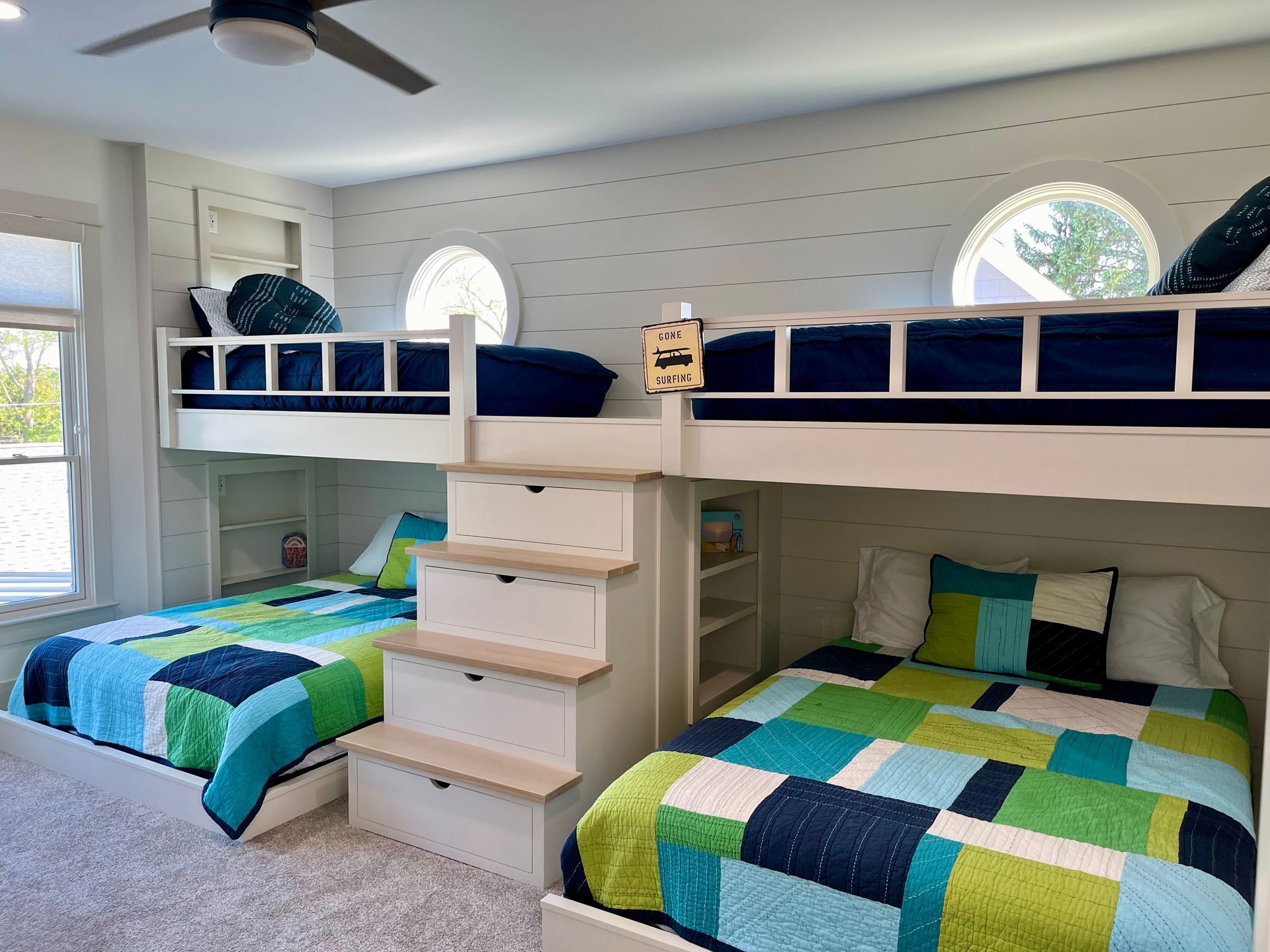 A bedroom with three bunk beds and a ceiling fan.