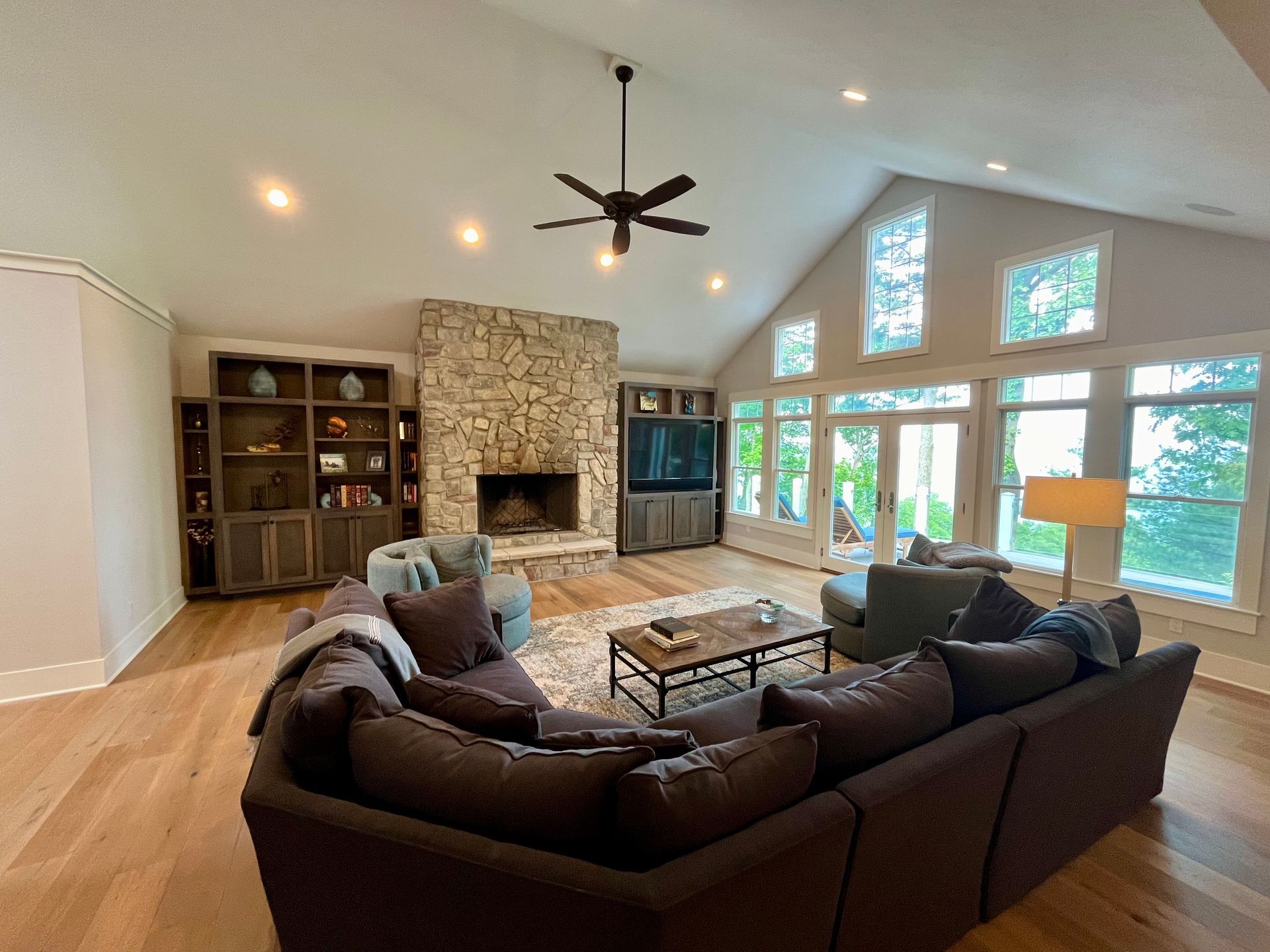 A living room filled with furniture and a fireplace with a ceiling fan.