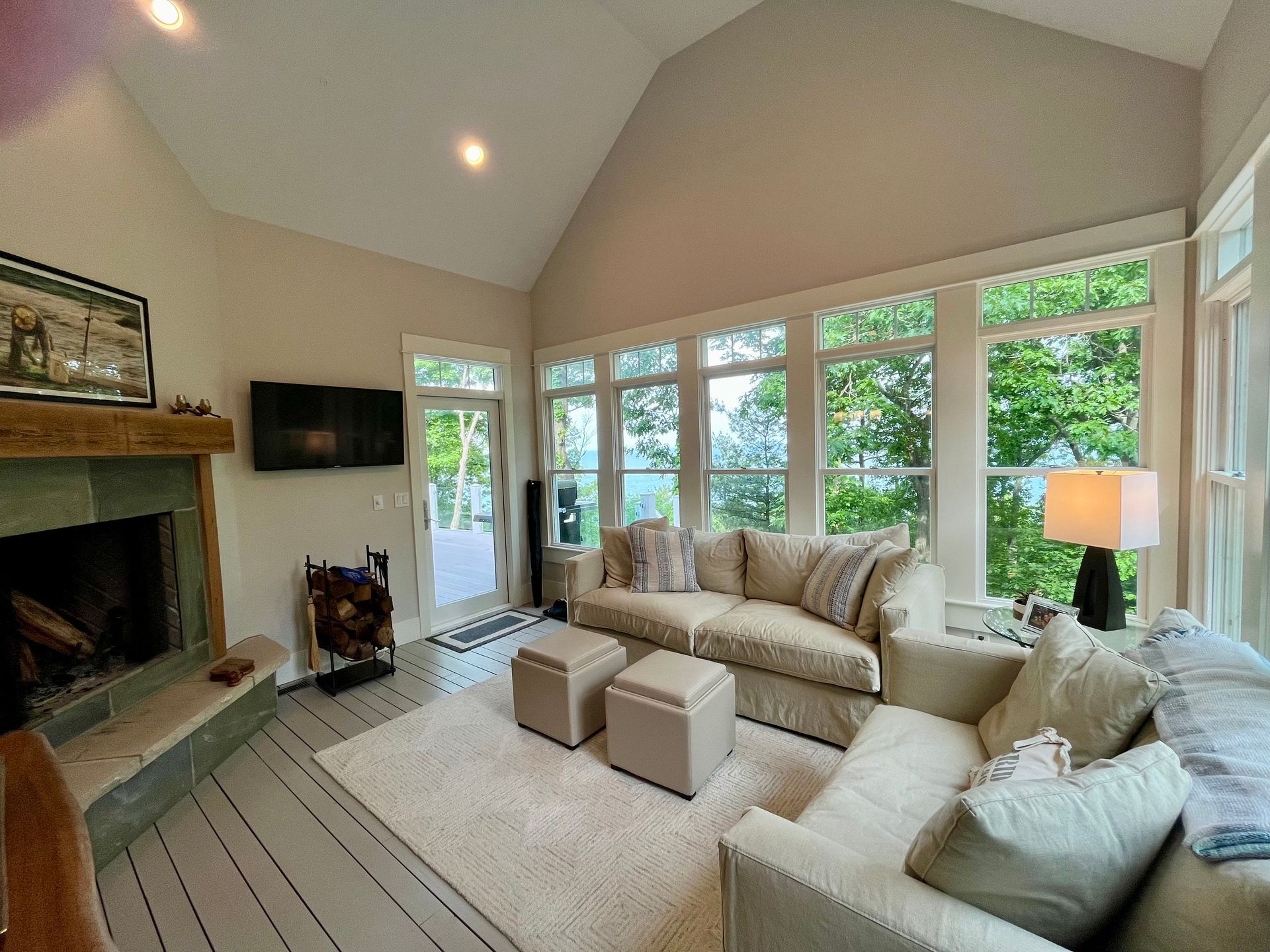 A living room with a couch , chairs , fireplace and television.