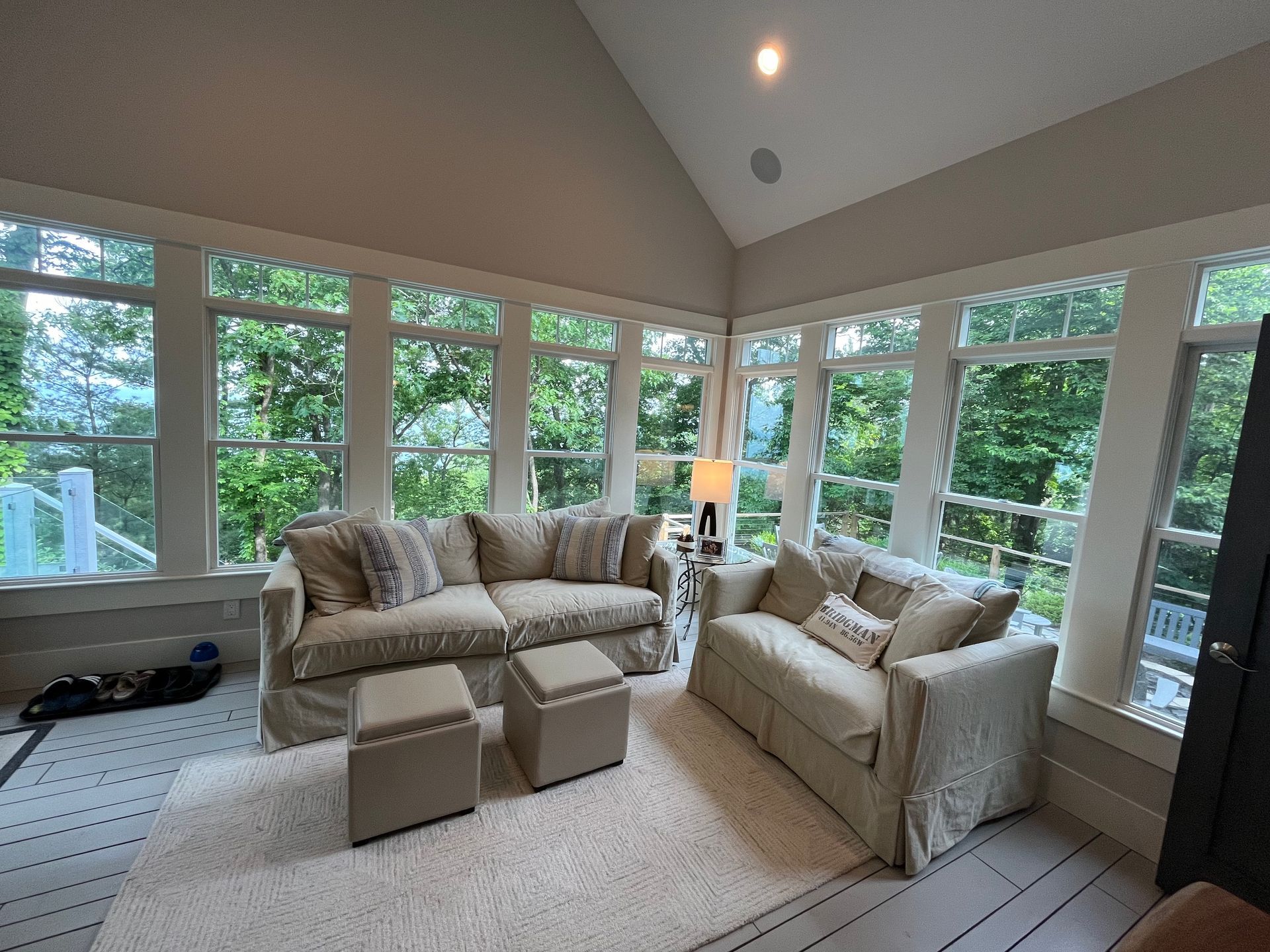 A living room with a vaulted ceiling and lots of windows