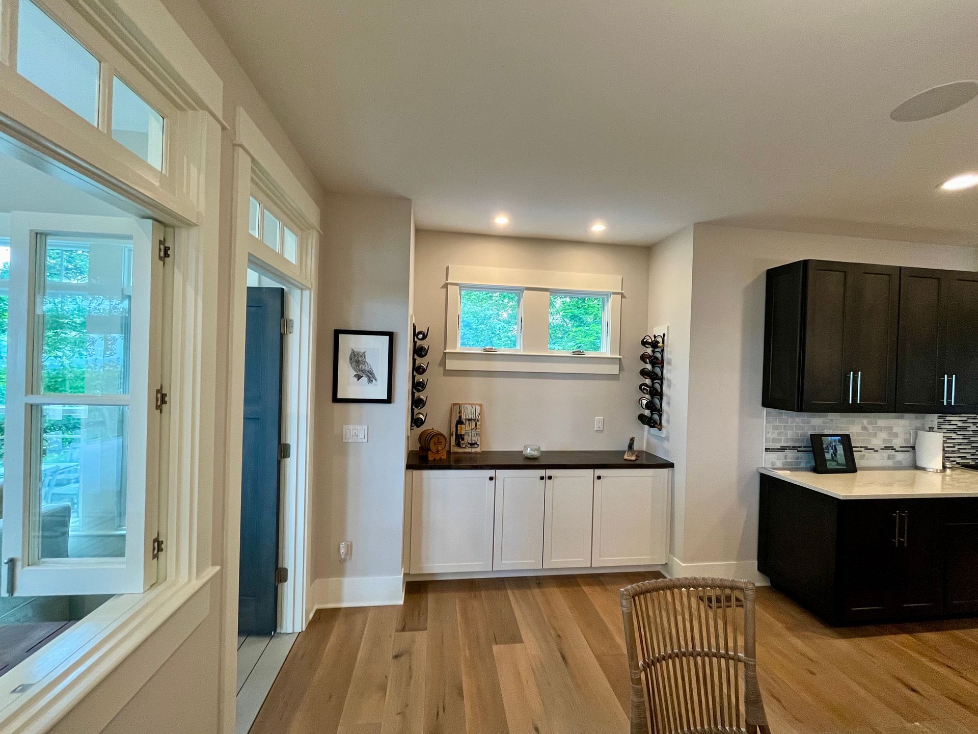 A kitchen with white cabinets and black counter tops