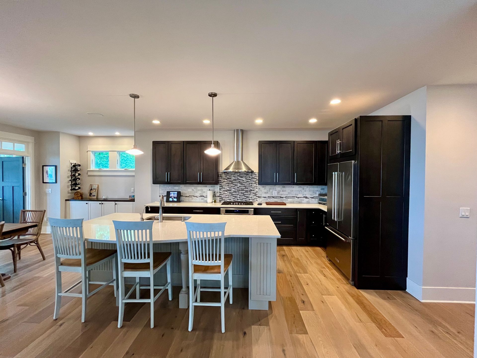 A kitchen with a large island and chairs in it