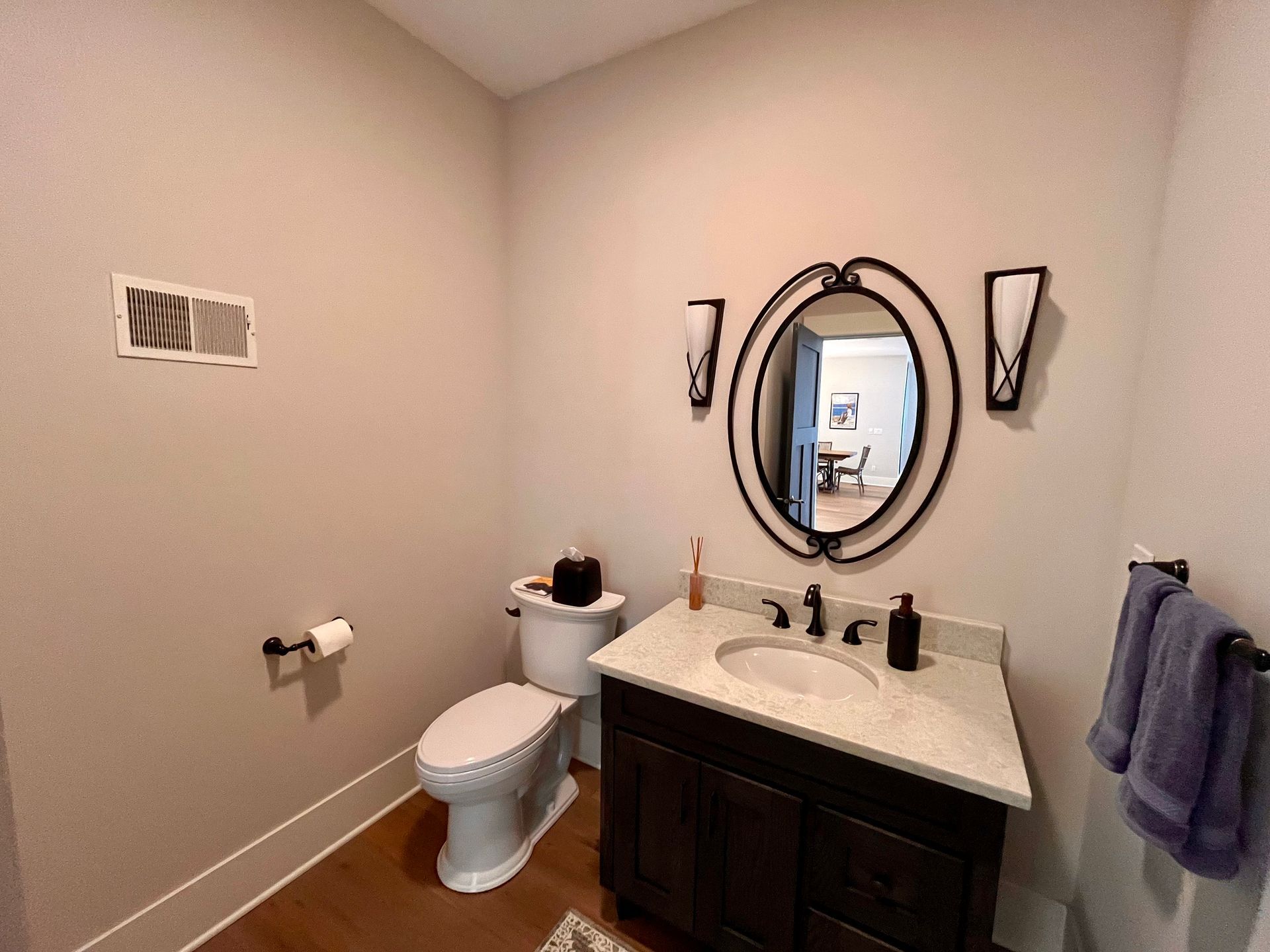 A bathroom with a toilet , sink and mirror.