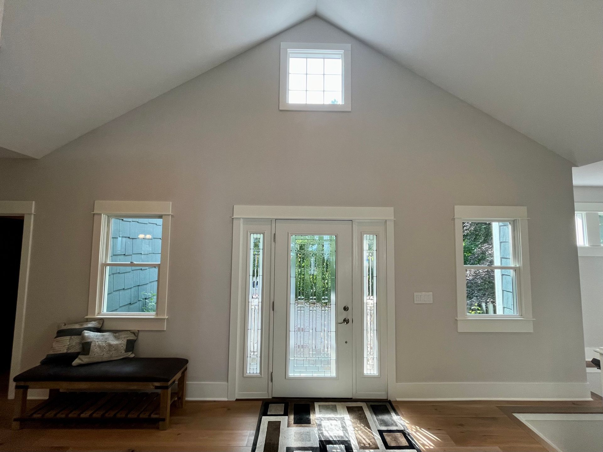 A living room with a vaulted ceiling and a door