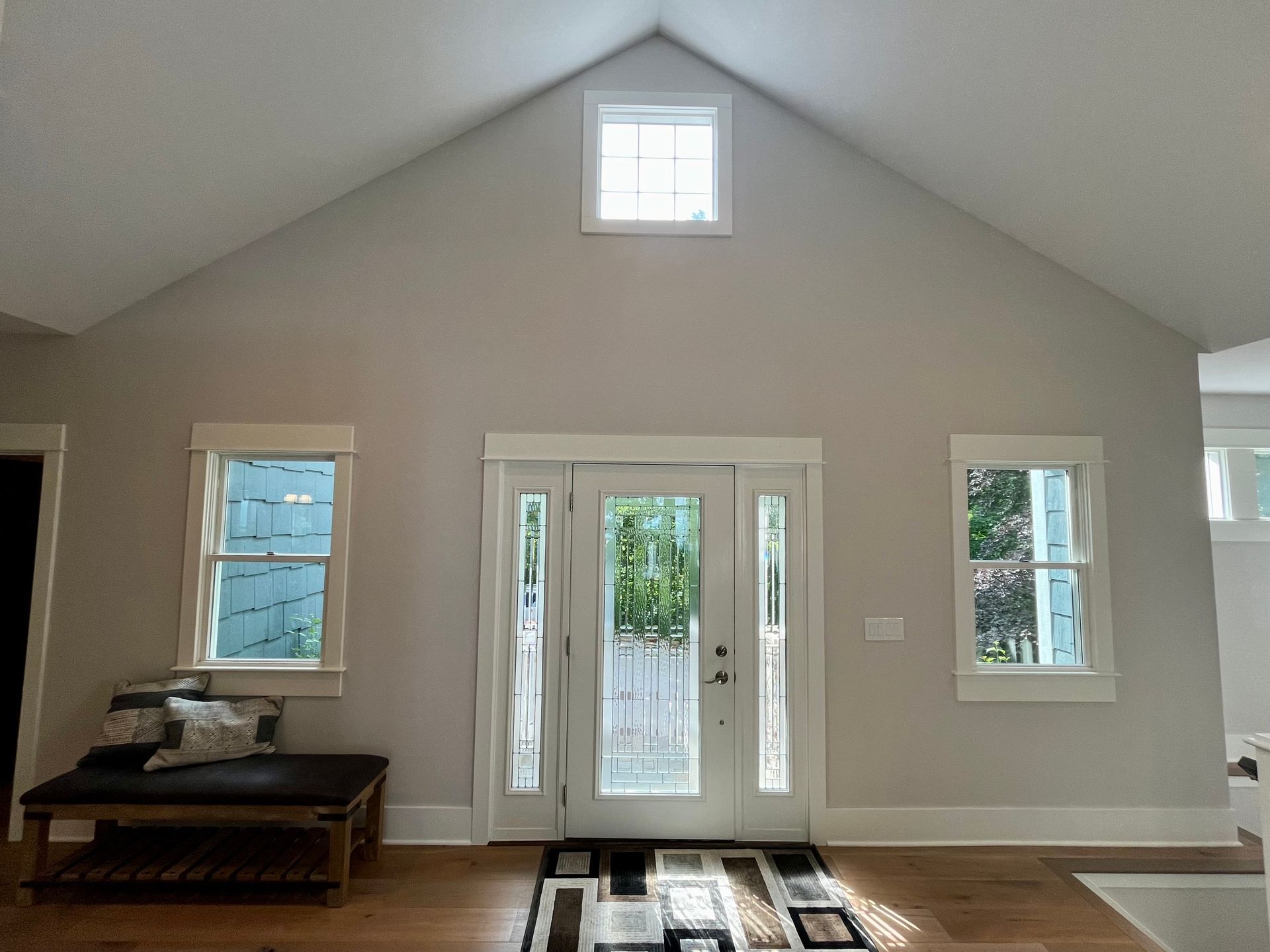 A living room with a vaulted ceiling and lots of windows