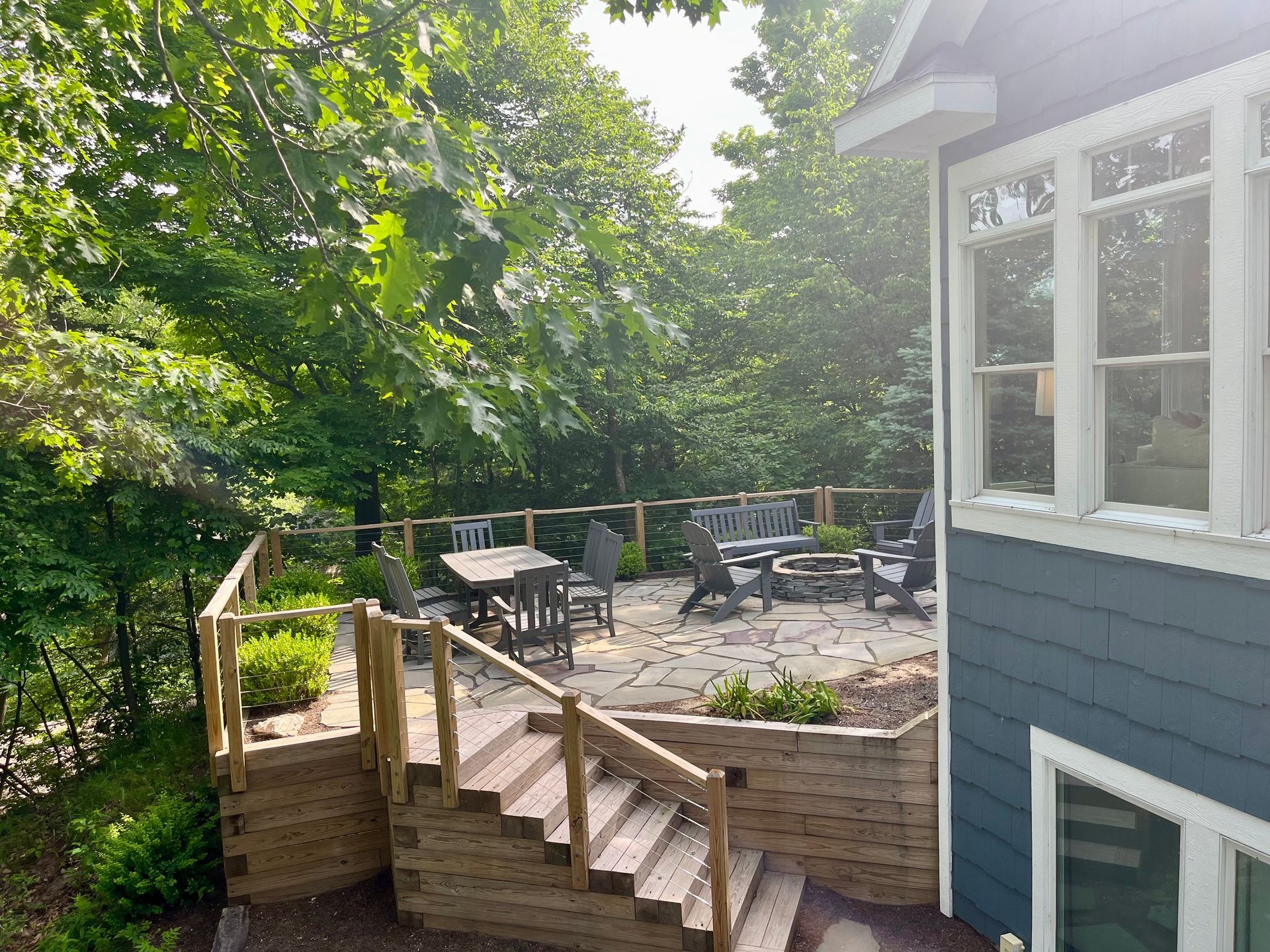 A blue house with a wooden deck and stairs