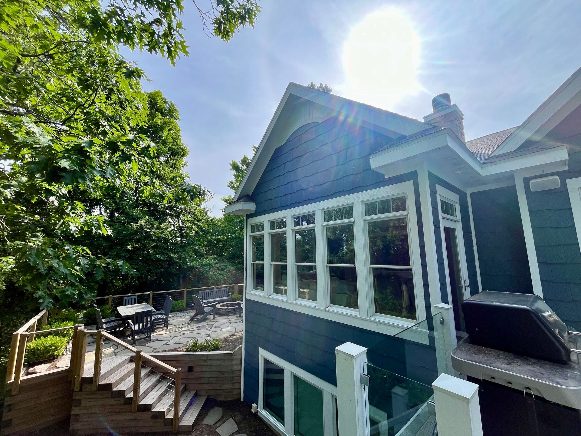 A blue and white house with a hot tub in the backyard.