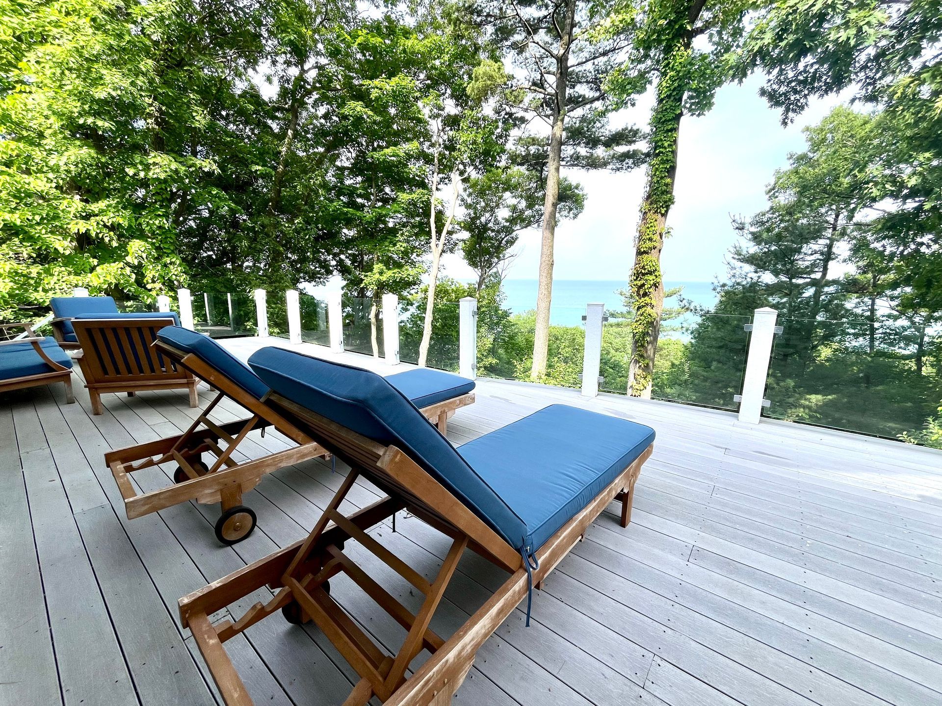 A deck with lawn chairs and a view of the ocean