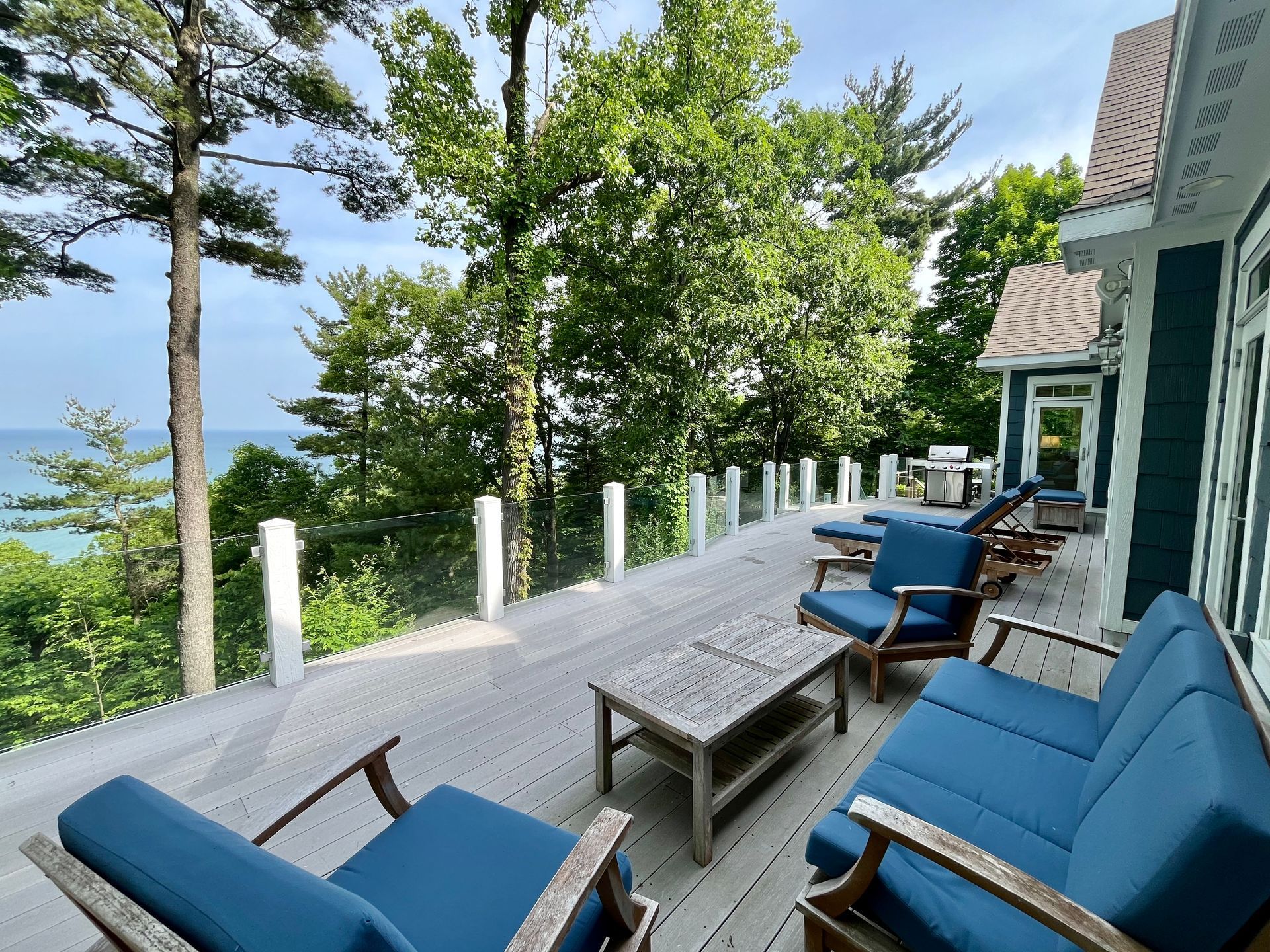 A deck with a view of the ocean and trees