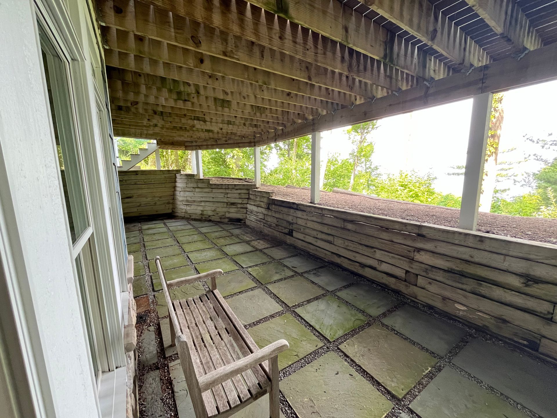 There is a bench on the porch of a house.