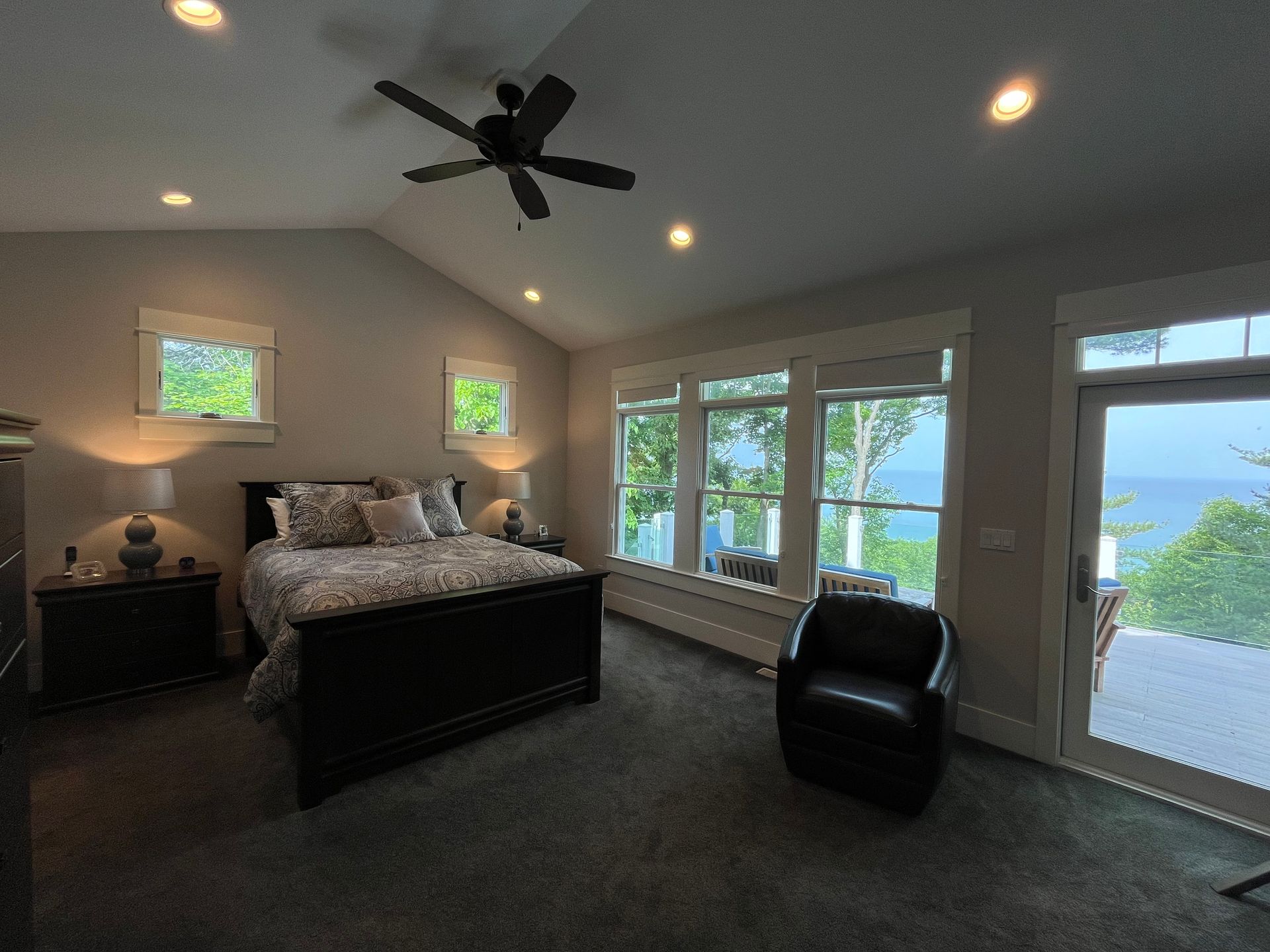 A bedroom with a large bed and a ceiling fan