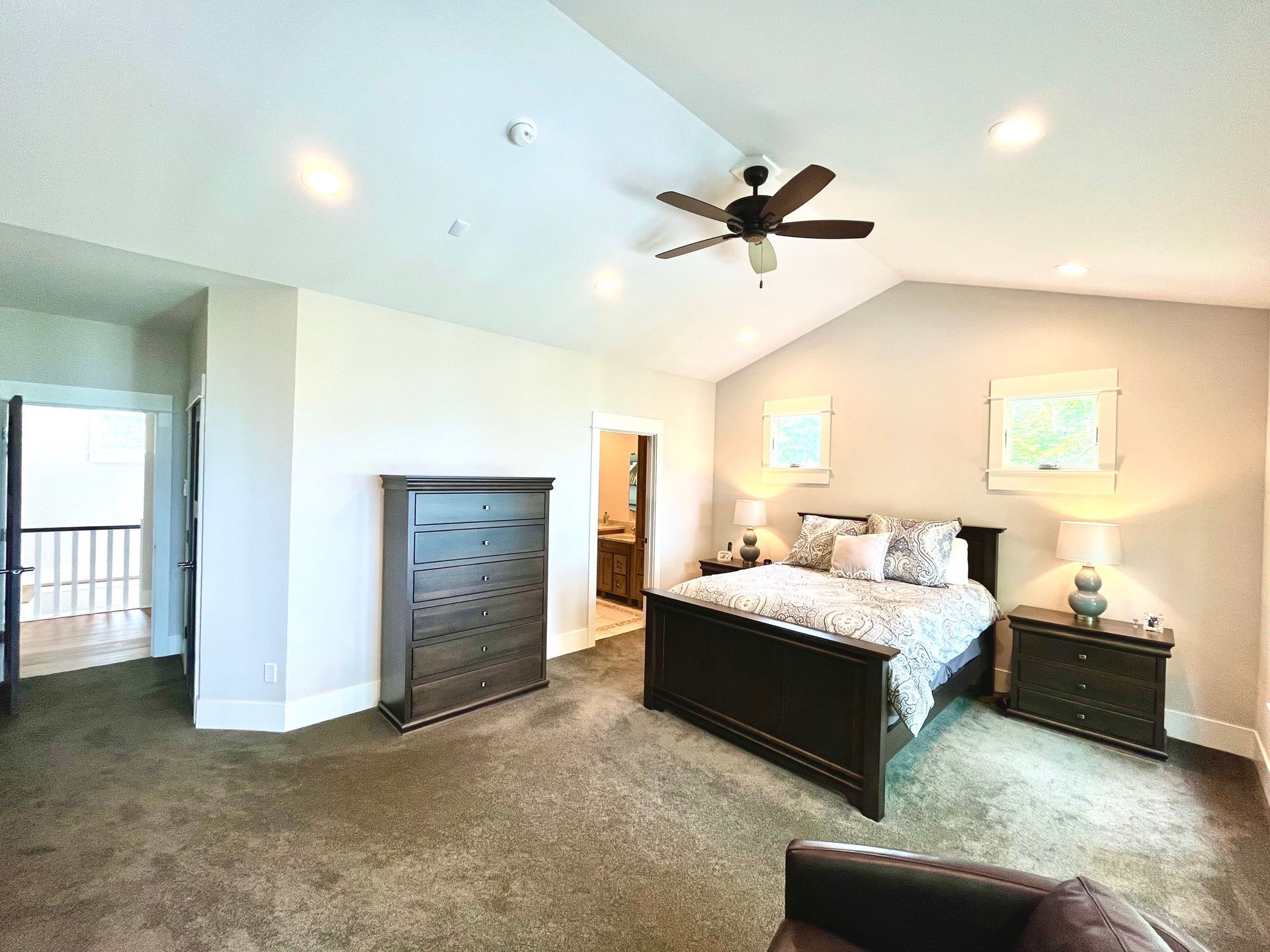 A bedroom with a bed , dresser , nightstand , and ceiling fan.