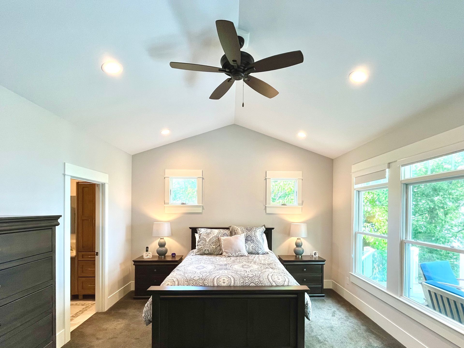 A bedroom with a bed and a ceiling fan