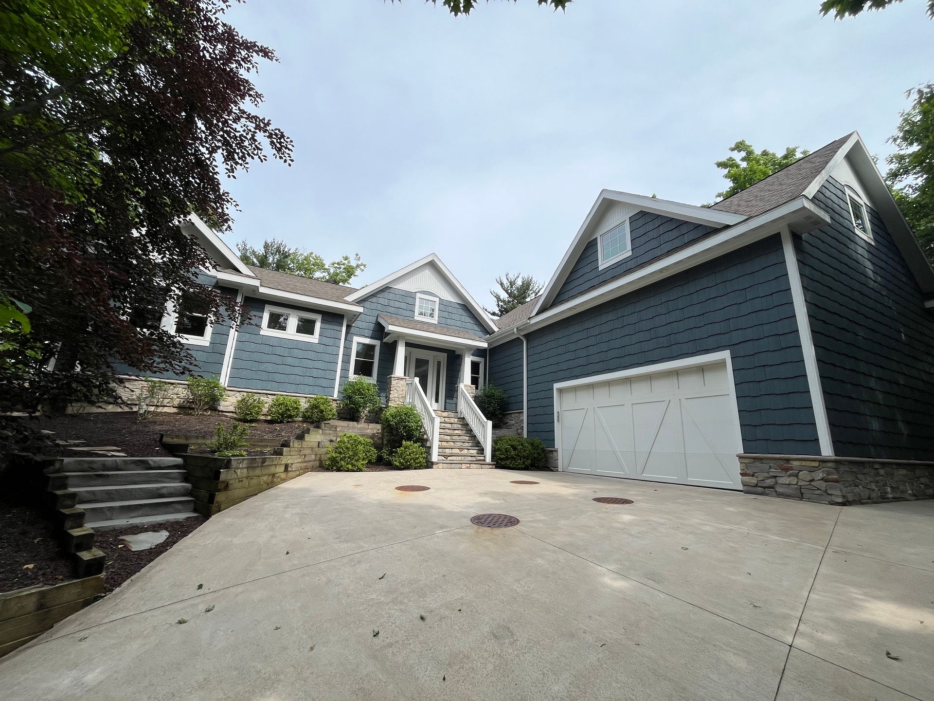 A large blue house with a white garage door