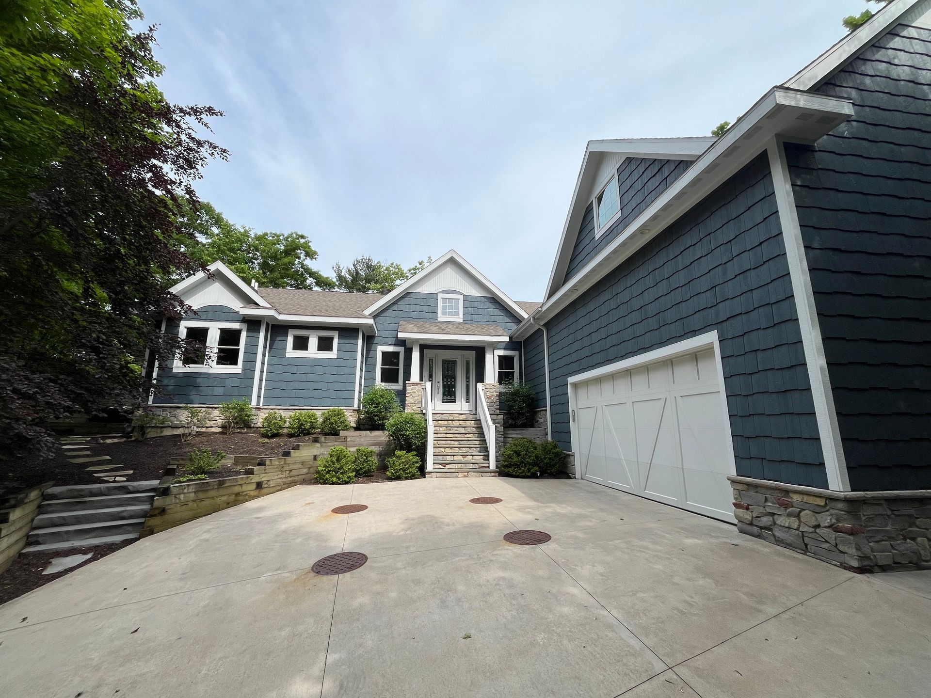 A large blue house with a white garage door