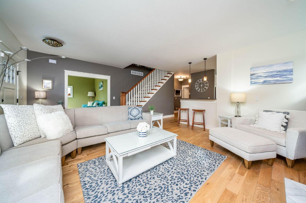 A living room with a couch , chair , coffee table and rug.