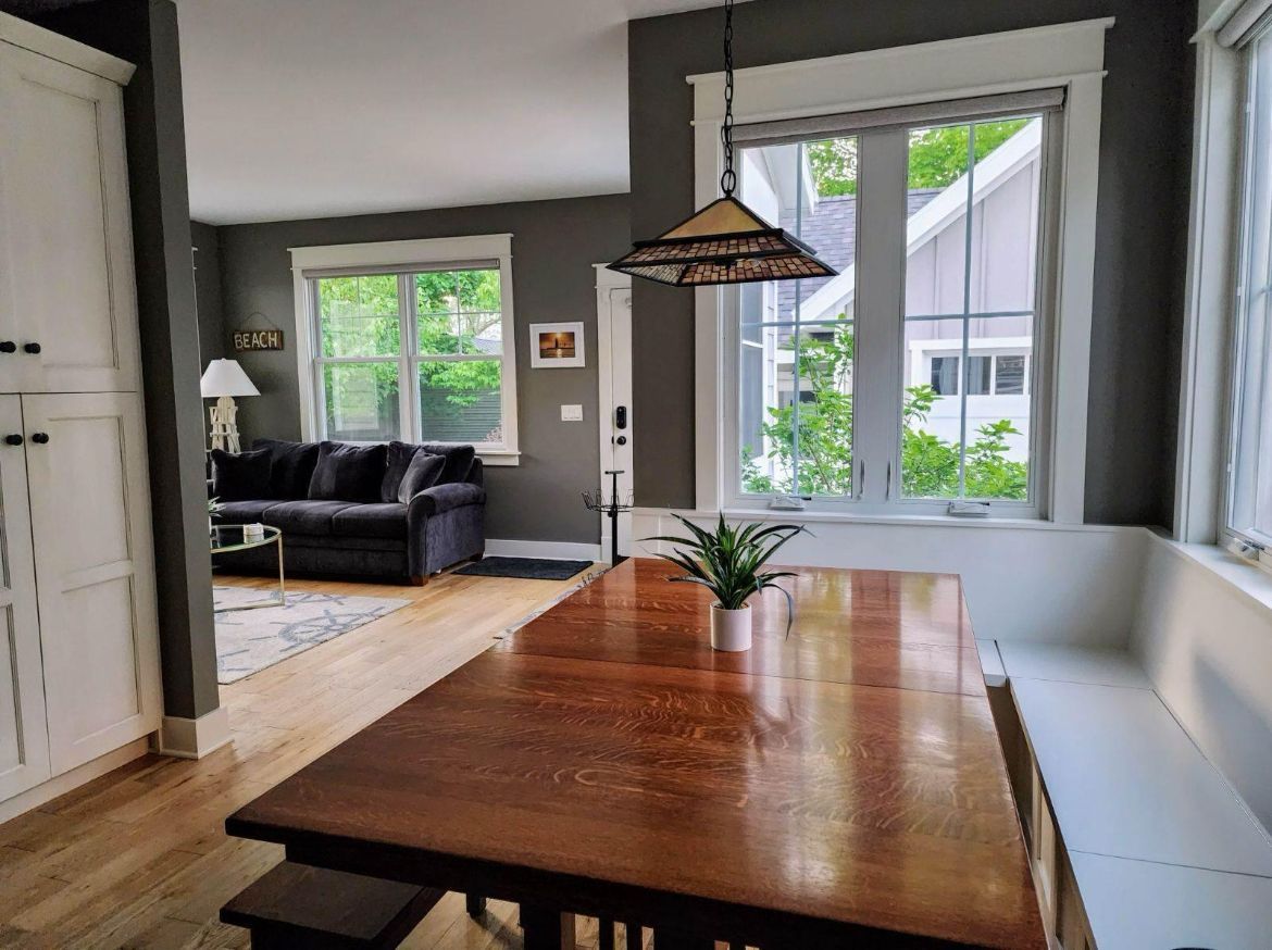 A dining room table with a bench and a couch in the background.