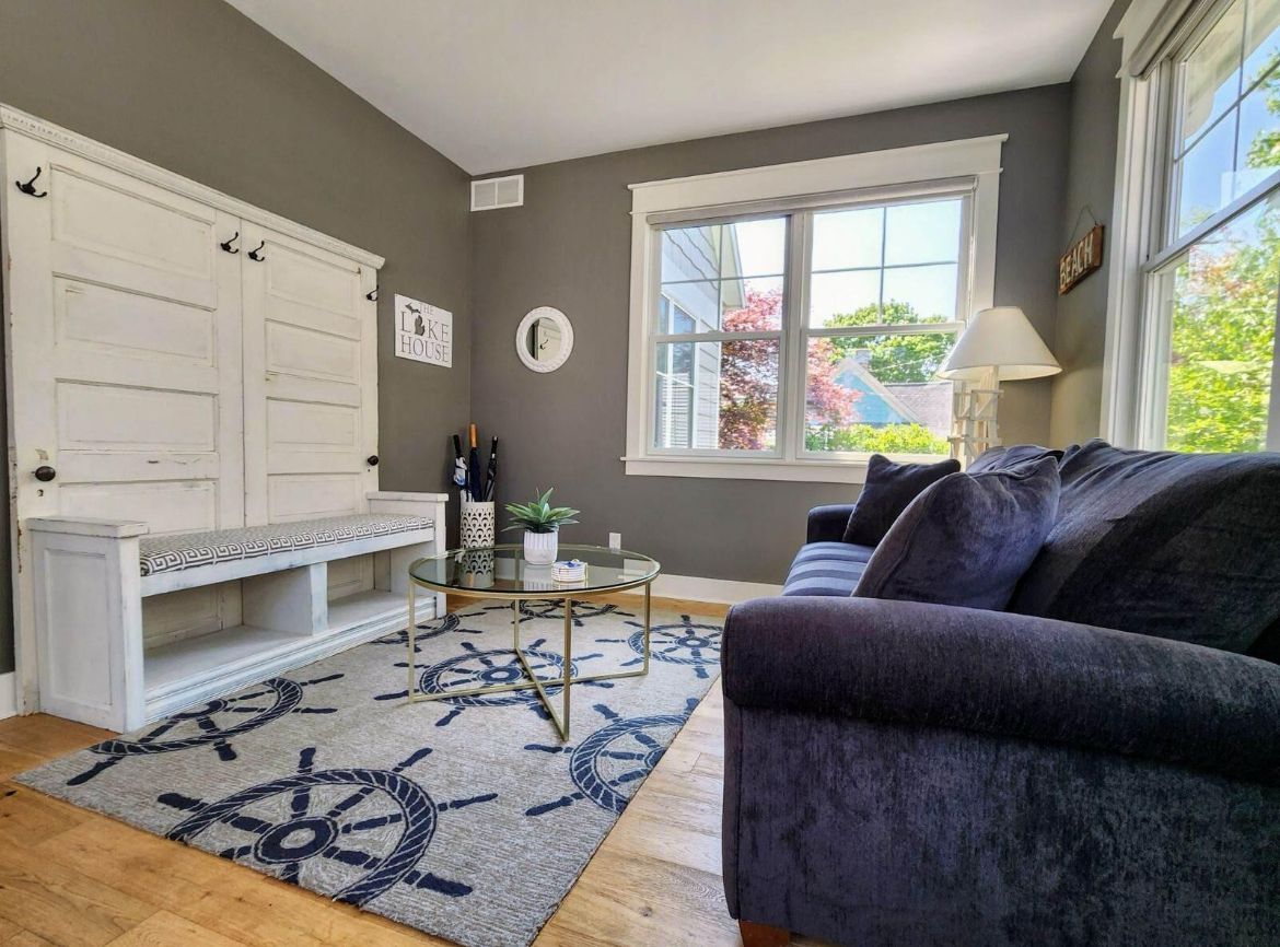 A living room with a couch , chair , table and window.