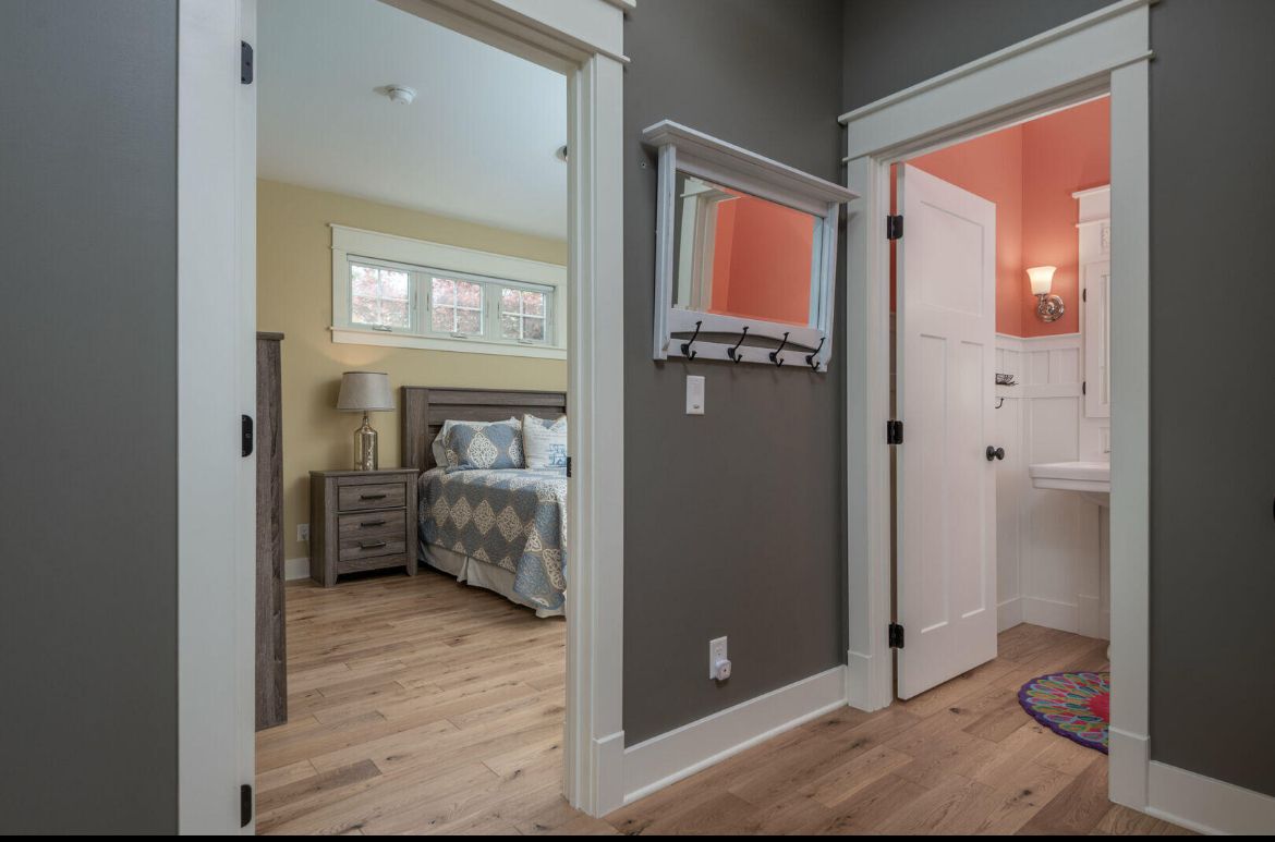 A hallway leading to a bedroom and bathroom in a house.