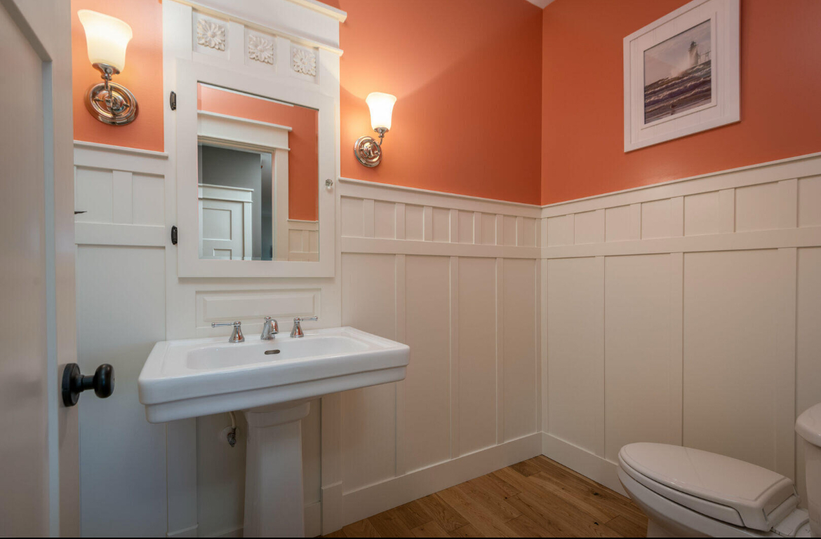 A bathroom with a sink a toilet and a mirror