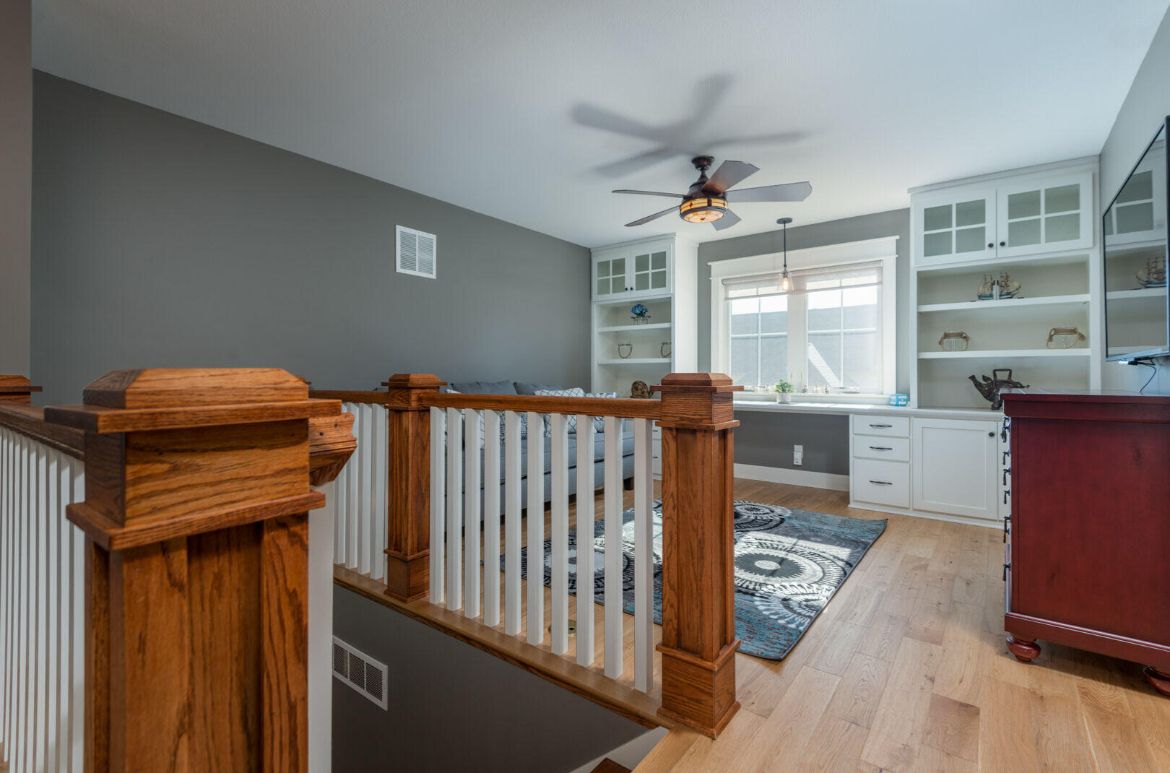 A living room with hardwood floors and a ceiling fan.