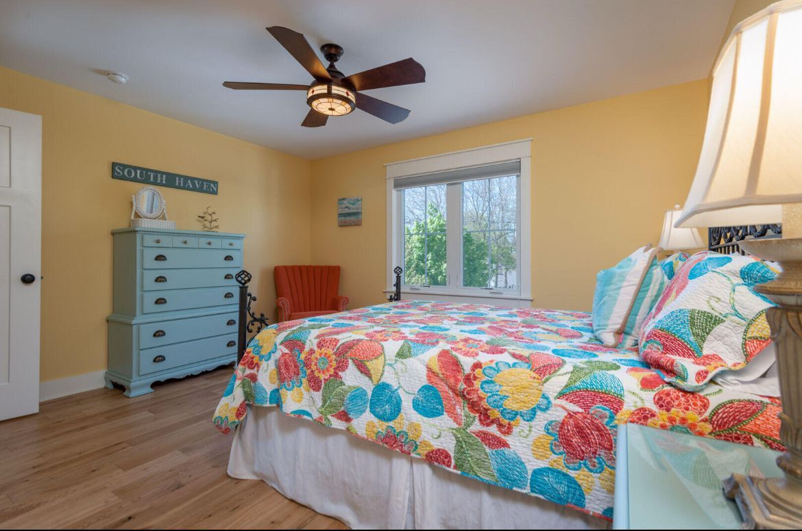 A bedroom with a large bed and a ceiling fan