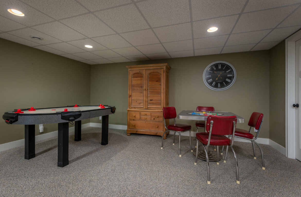 A game room with a pool table and a table and chairs.