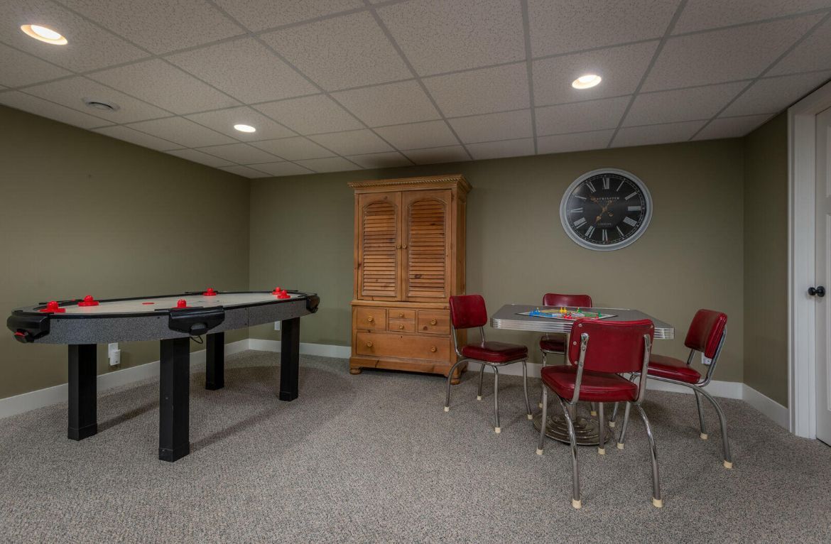 A game room with a pool table and a table and chairs.
