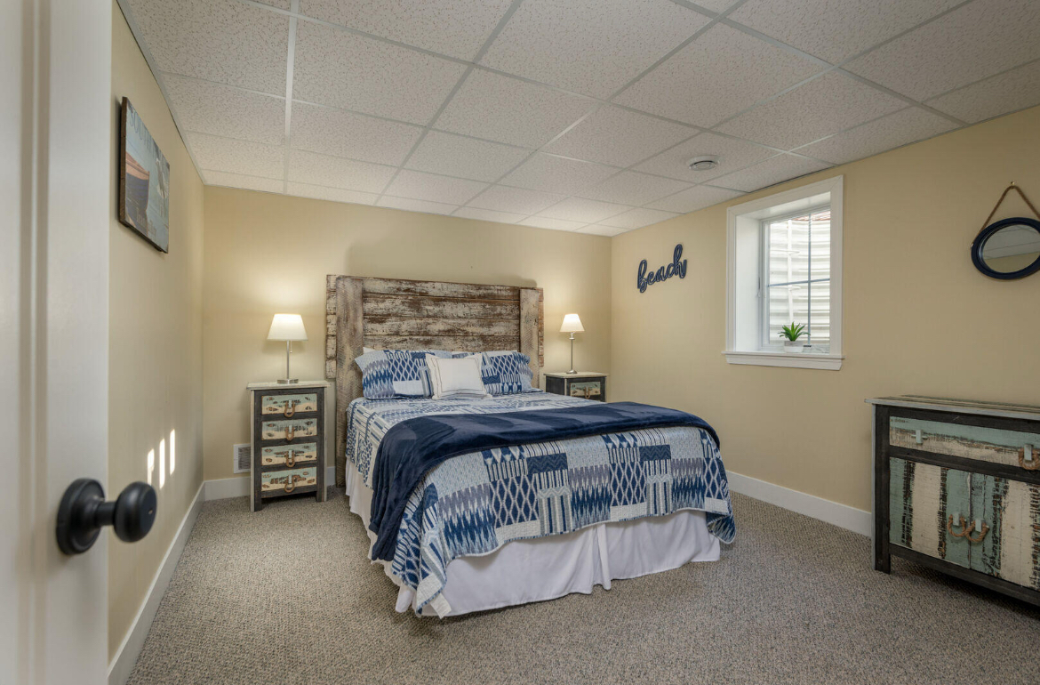 A bedroom with a bed , nightstands , and a window.