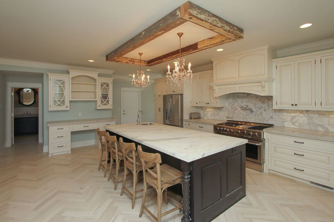 A kitchen with a large island and a chandelier hanging from the ceiling.