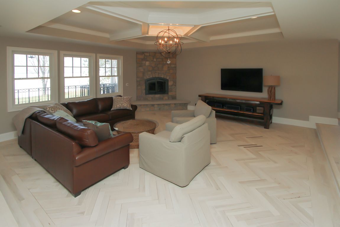 A living room with a couch , chairs , television and fireplace