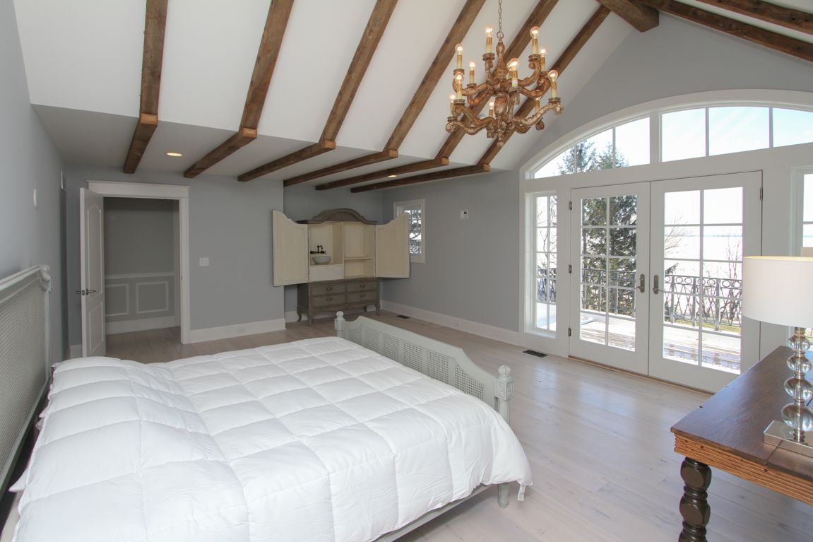 A bedroom with a large bed and a chandelier