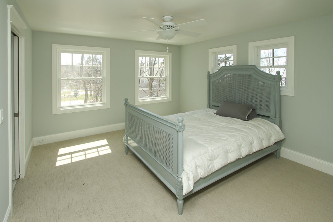 A bedroom with a bed and a ceiling fan