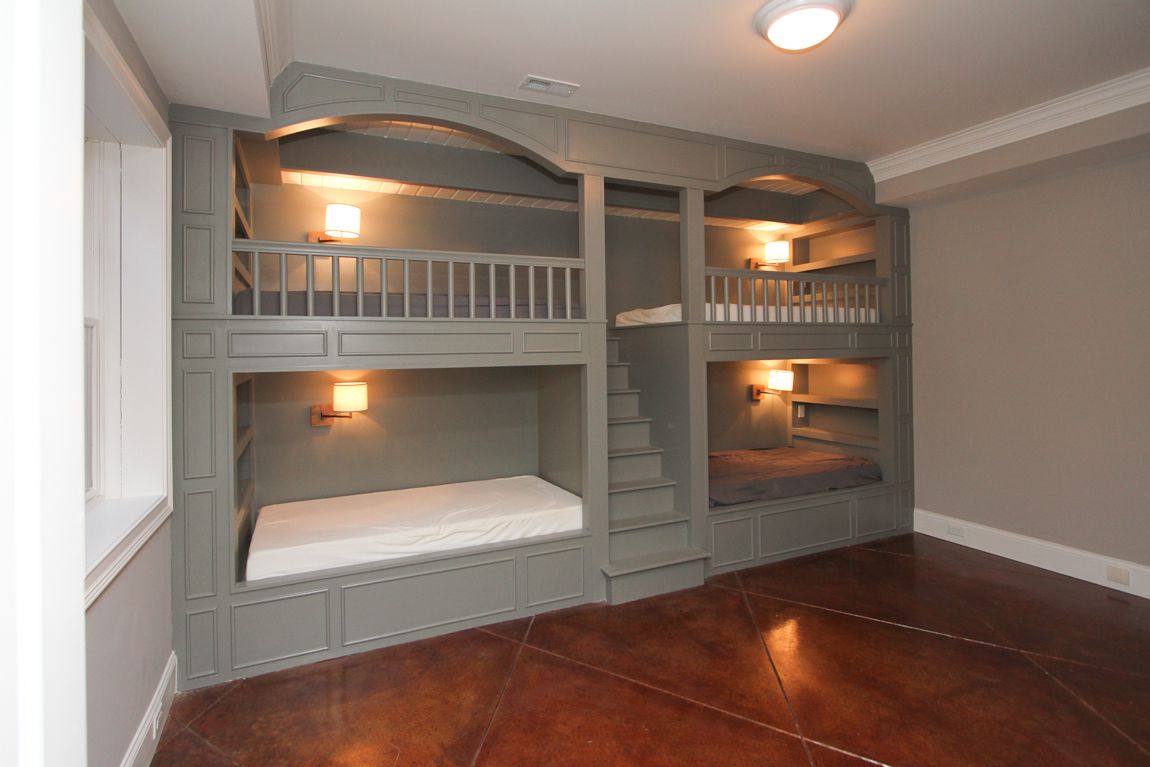 A room with bunk beds and stairs in it
