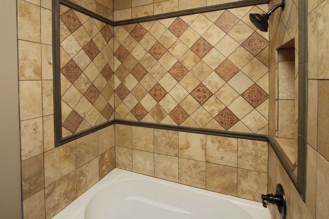 A bathtub in a bathroom with tiled walls and a shower head