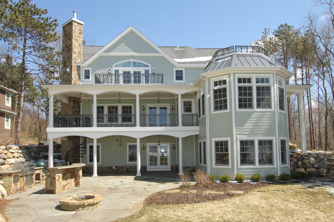 A large house with a lot of windows and a fire pit in front of it.