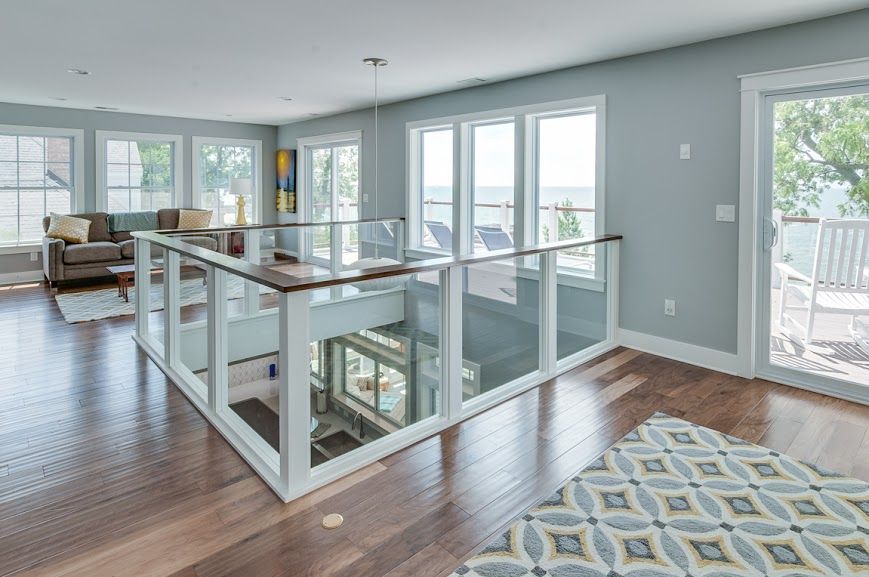A living room with a balcony and lots of windows
