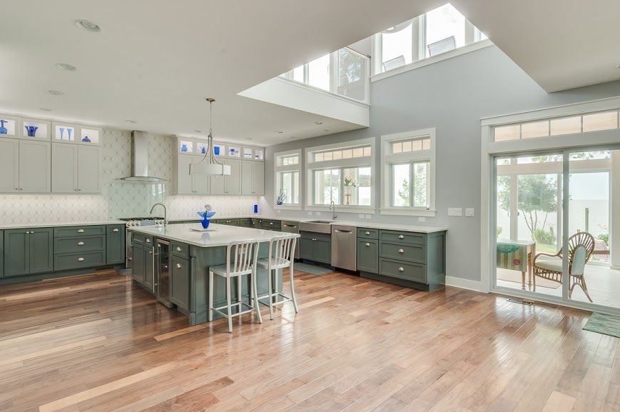 A large kitchen with a lot of windows and hardwood floors.