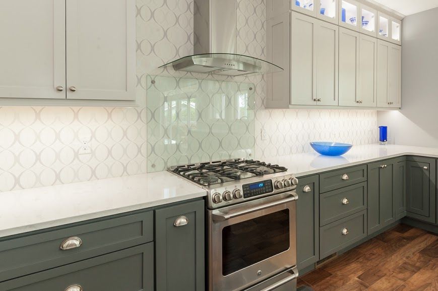 A kitchen with stainless steel appliances and gray cabinets.