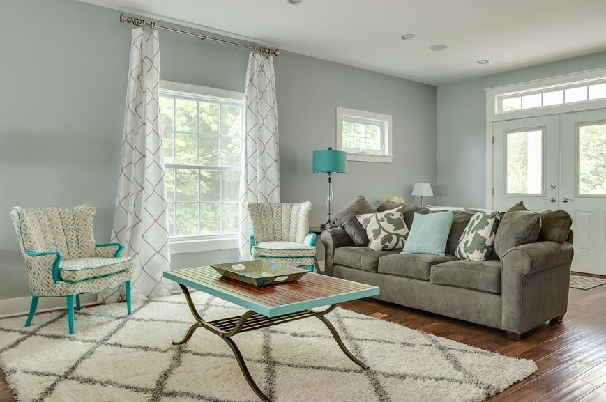 A living room with a couch , chairs , and a coffee table.