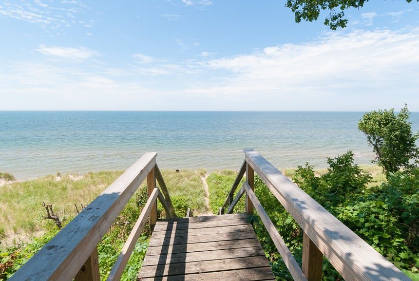 A wooden walkway leading to the ocean on a sunny day