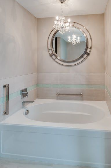 A bathroom with a bathtub and a mirror.