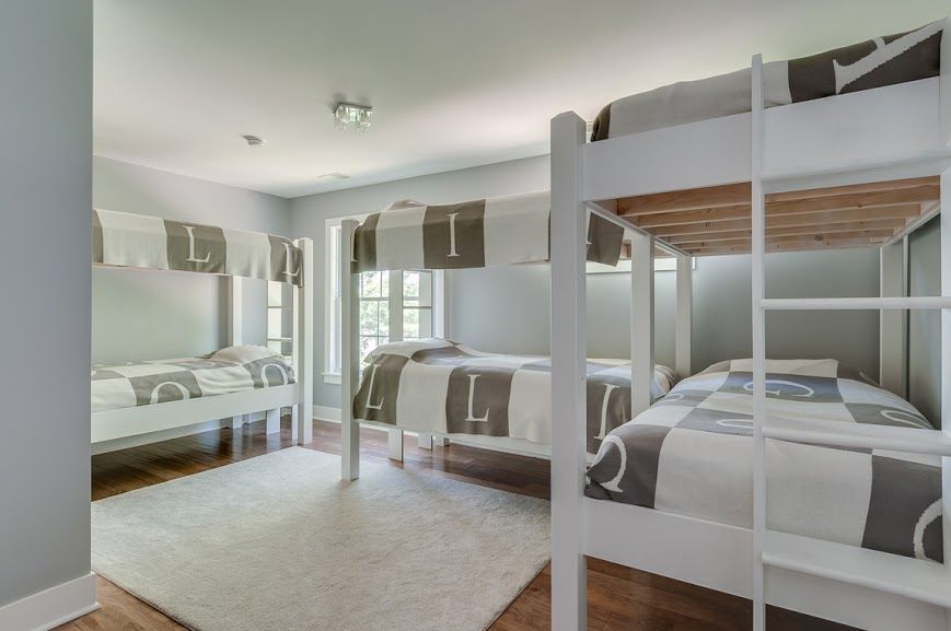 A bedroom with four bunk beds and a rug.