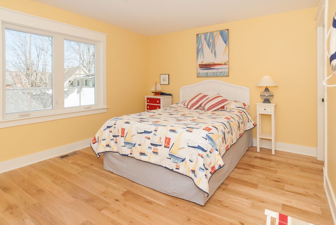 A bedroom with a large bed and a painting on the wall.