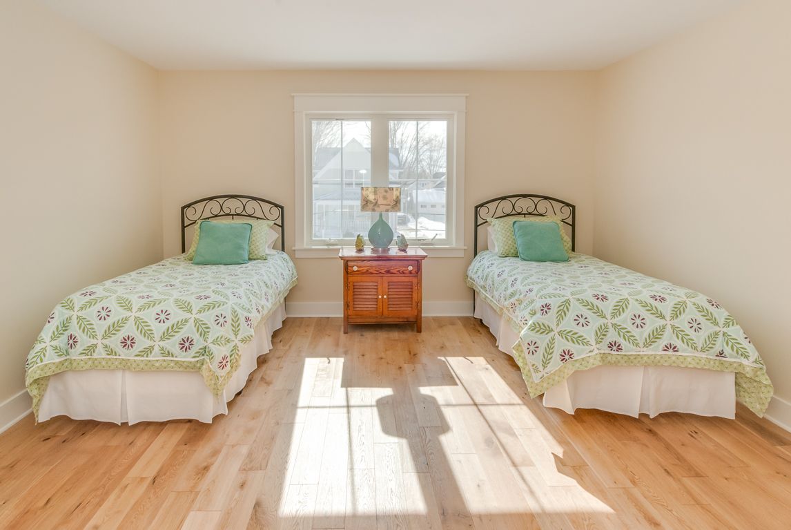 A bedroom with two twin beds and a window.