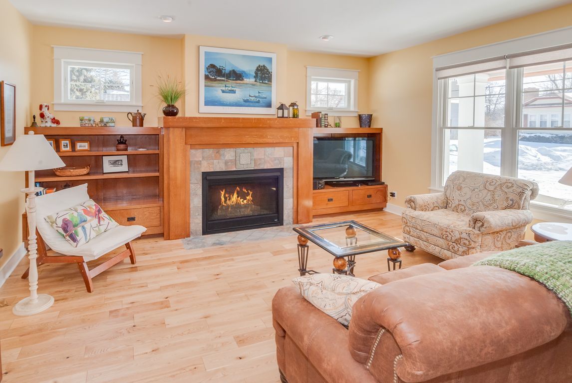 A living room with a fireplace , couch , chair and television.